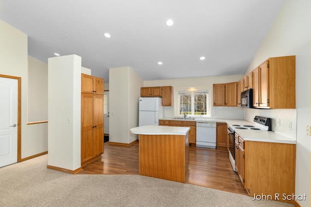 7588 Rivendell Dr SE, Grand Rapids, MI 49508 - kitchen featuring light countertops, a sink, a center island, white appliances, and recessed lighting
