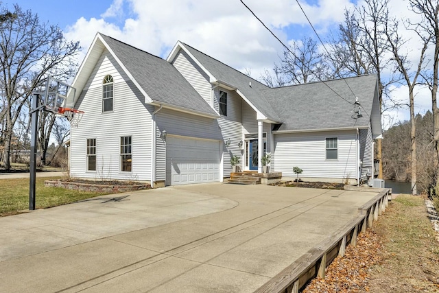 11262 Lemott Cir, Jerome, MI 49249 - view of side of property with driveway, a garage, central AC unit, and roof with shingles