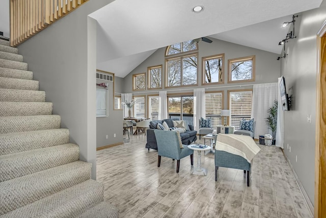 11262 Lemott Cir, Jerome, MI 49249 - living area with light wood finished floors, high vaulted ceiling, baseboards, and stairs