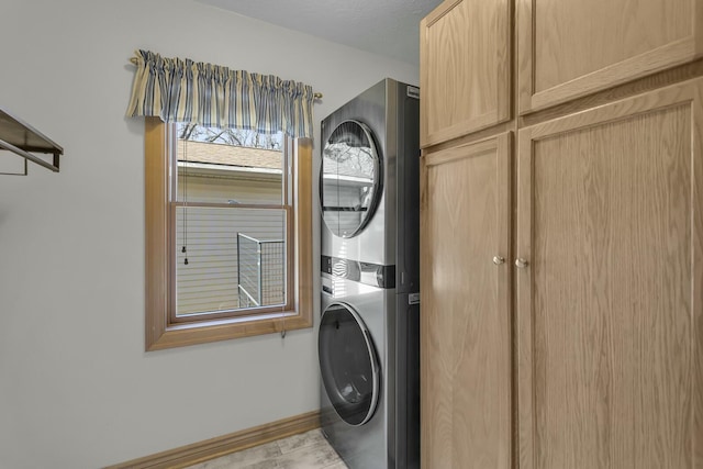 11262 Lemott Cir, Jerome, MI 49249 - laundry area with stacked washer and dryer, cabinet space, and baseboards