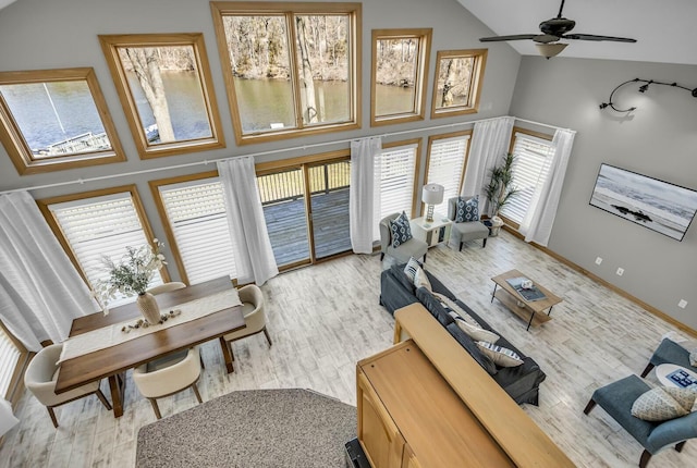 11262 Lemott Cir, Jerome, MI 49249 - living room with a ceiling fan, high vaulted ceiling, baseboards, and light wood finished floors