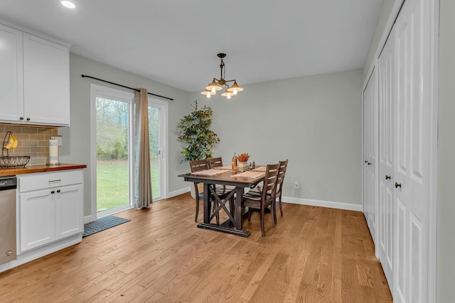 dining space with light wood finished floors, baseboards, a chandelier, and recessed lighting