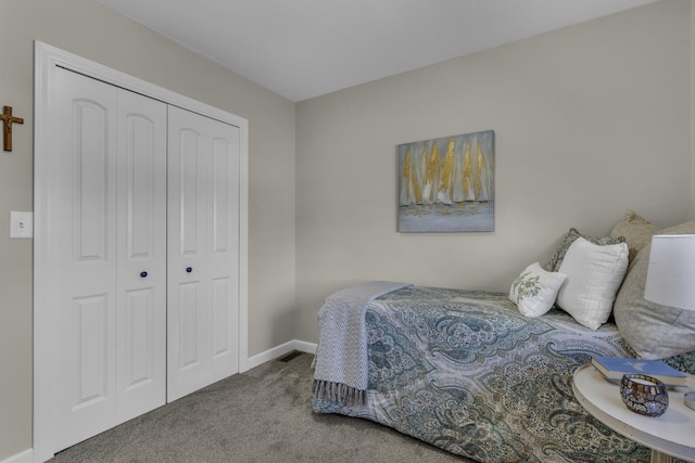 carpeted bedroom featuring baseboards and a closet