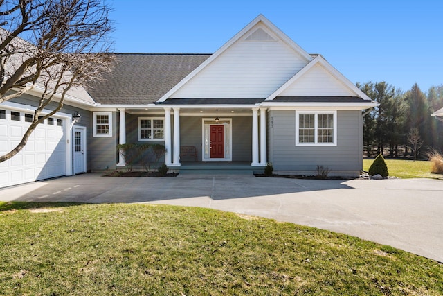 view of front of house with concrete driveway, a garage, a front lawn, a shingled roof, and a porch