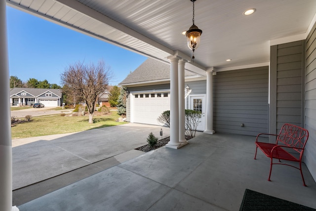 view of patio featuring driveway and a garage