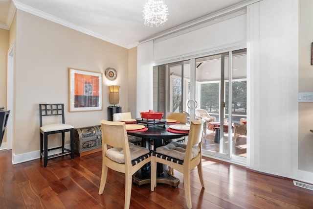 dining space featuring ornamental molding, dark wood-type flooring, baseboards, visible vents, and a notable chandelier