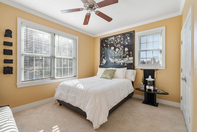 carpeted bedroom featuring baseboards, ornamental molding, and a ceiling fan