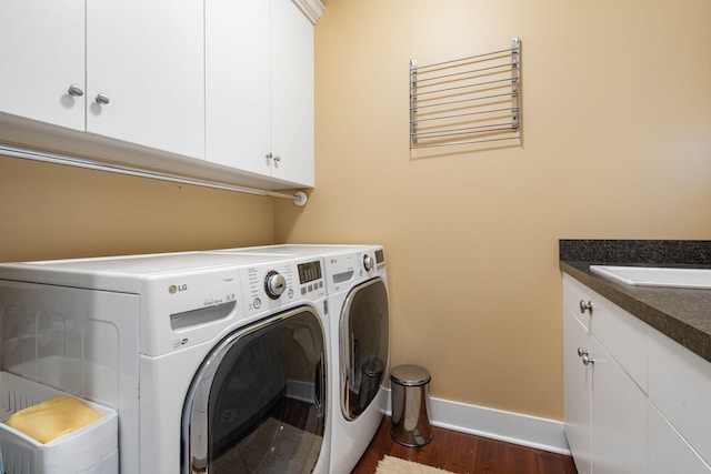 laundry area with baseboards, cabinet space, independent washer and dryer, and dark wood finished floors