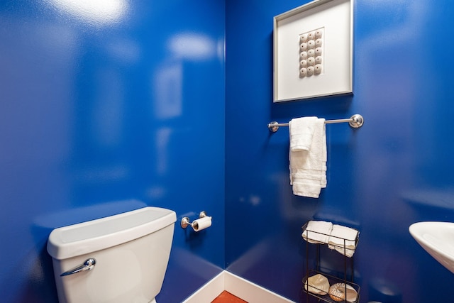 bathroom with baseboards and toilet