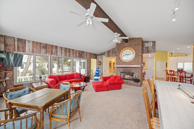 4103 Lake Shore Dr, New Buffalo, MI 49117 - carpeted dining space featuring a brick fireplace, a ceiling fan, vaulted ceiling with beams, and visible vents