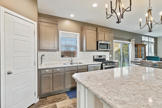 19372 M 140, South Haven, MI 49090 - kitchen featuring tasteful backsplash, an inviting chandelier, stainless steel appliances, a sink, and light wood-style floors