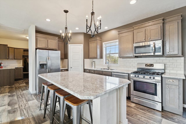 19372 M 140, South Haven, MI 49090 - kitchen featuring a sink, tasteful backsplash, a center island, stainless steel appliances, and an inviting chandelier