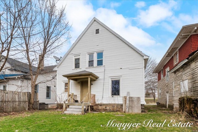 1403 Turner Ave NW, Grand Rapids, MI 49504 - rear view of house with a lawn, fence, and cooling unit