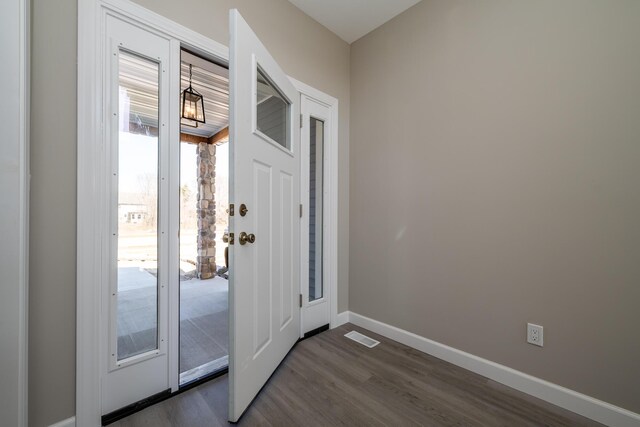 entryway with baseboards, visible vents, and dark wood-style floors
