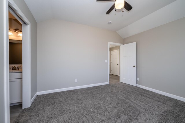 unfurnished bedroom featuring carpet flooring, vaulted ceiling, baseboards, ceiling fan, and ensuite bath