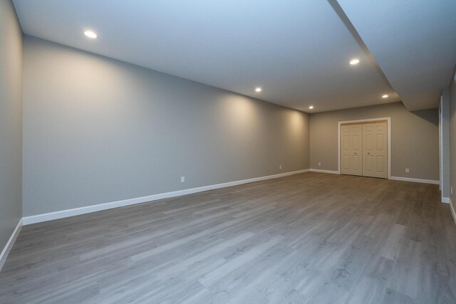 finished below grade area featuring wood finished floors, baseboards, and recessed lighting