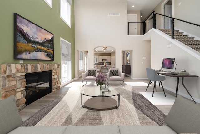 living room featuring baseboards, wood finished floors, a wealth of natural light, and stairs