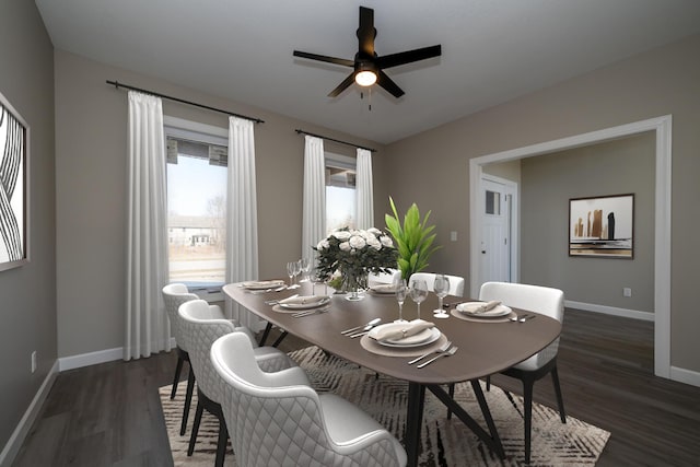 dining space with ceiling fan, baseboards, and dark wood-type flooring