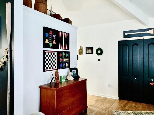foyer entrance featuring lofted ceiling with beams and wood finished floors