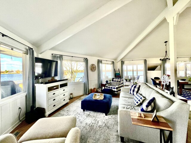 living area featuring plenty of natural light, vaulted ceiling with beams, and wood finished floors