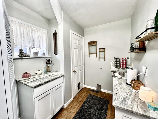 kitchen with white cabinetry, open shelves, dark wood-style flooring, baseboards, and light stone counters
