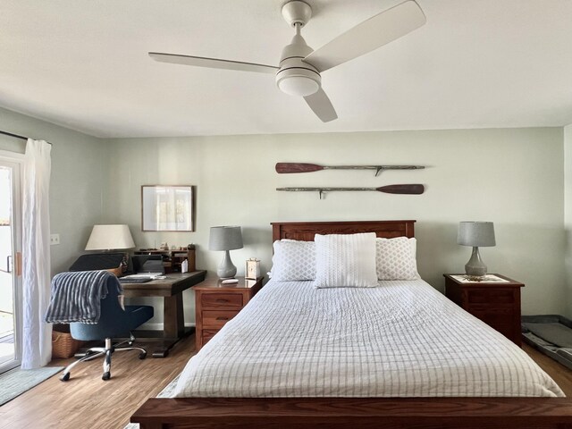 bedroom featuring wood finished floors, multiple windows, and a ceiling fan