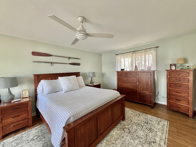 bedroom featuring a ceiling fan, baseboards, and light wood-style floors