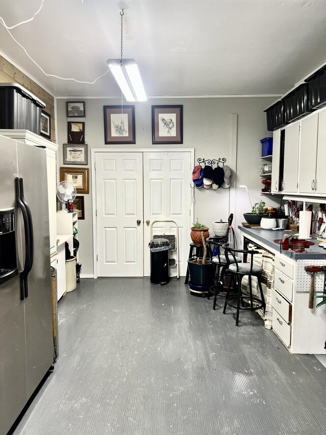 kitchen with white cabinetry, stainless steel refrigerator with ice dispenser, and open shelves