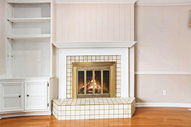 17650 Woodbridge Rd # 1, Spring Lake, MI 49456 - detailed view of wood finished floors, ornamental molding, baseboards, and a tile fireplace