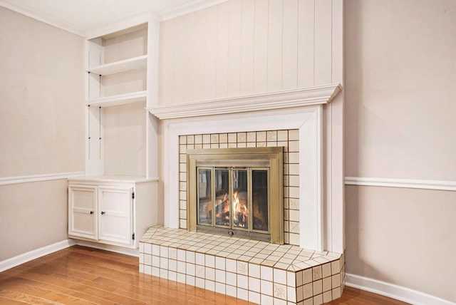 17650 Woodbridge Rd # 1, Spring Lake, MI 49456 - detailed view of wood finished floors, baseboards, a tiled fireplace, and ornamental molding