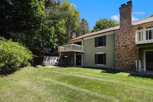 17650 Woodbridge Rd # 1, Spring Lake, MI 49456 - back of house featuring a chimney, a lawn, a wooden deck, and brick siding