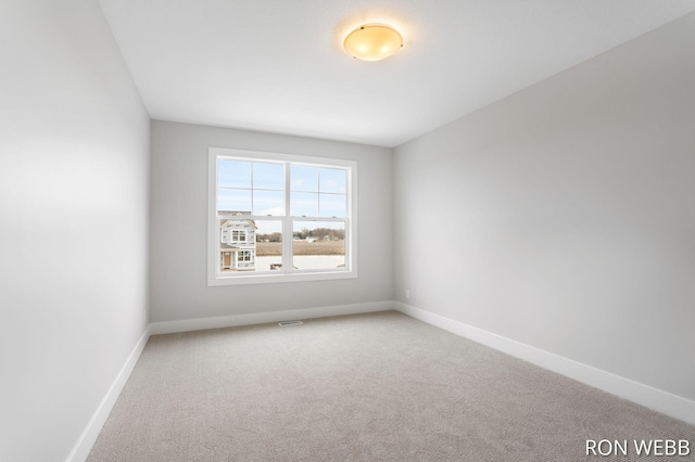 empty room featuring baseboards, visible vents, and carpet floors