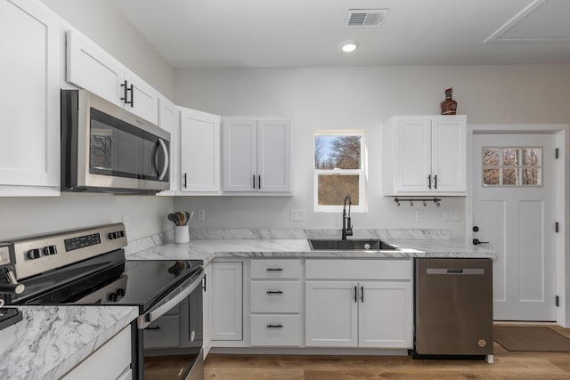 2084 W Fenwick Rd, Fenwick, MI 48834 - kitchen with white cabinetry, a sink, stainless steel appliances, and visible vents