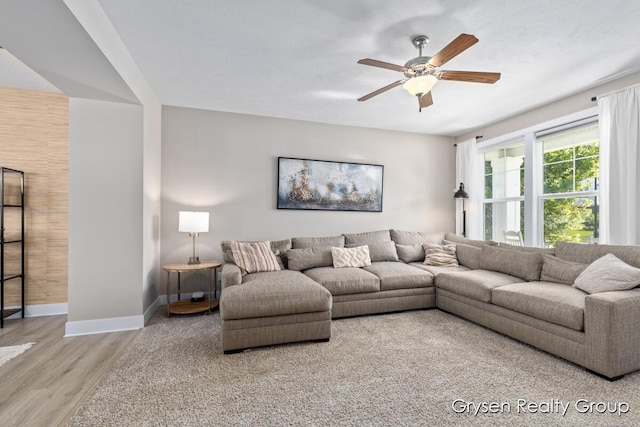 living area with wood finished floors, baseboards, and ceiling fan