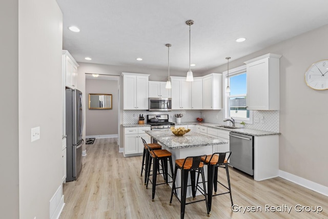 kitchen with appliances with stainless steel finishes, a sink, decorative backsplash, white cabinets, and recessed lighting