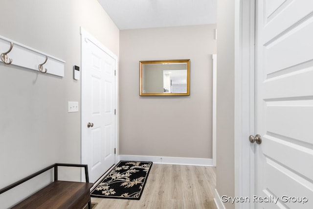 doorway with wood finished floors and baseboards