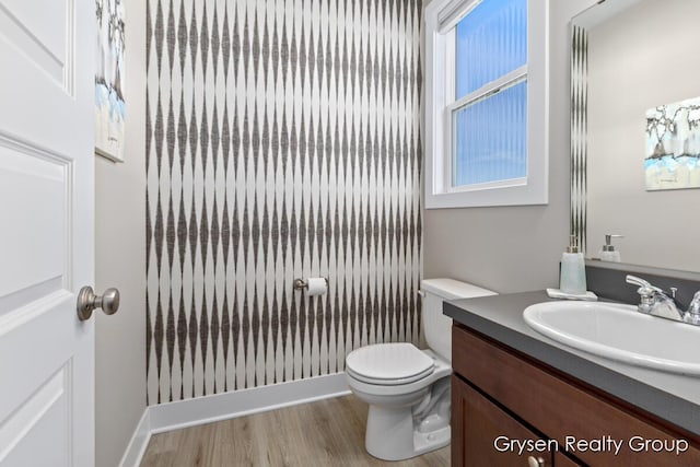bathroom featuring wood finished floors, vanity, and toilet
