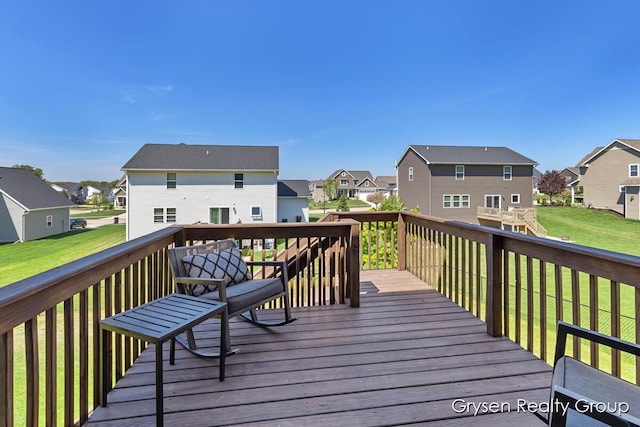 wooden terrace featuring a residential view and a lawn