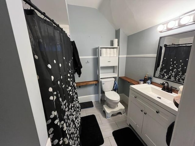 711 Randolph St, Jackson, MI 49203 - bathroom featuring lofted ceiling, toilet, vanity, tile patterned floors, and a shower with curtain