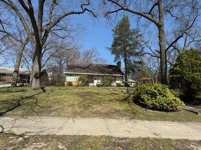 view of front of house featuring a front yard and a chimney