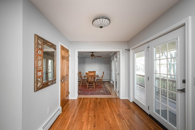 7295 Dutch Rd, Goodrich Vlg, MI 48438 - hallway featuring a baseboard radiator, baseboards, and light wood-style floors