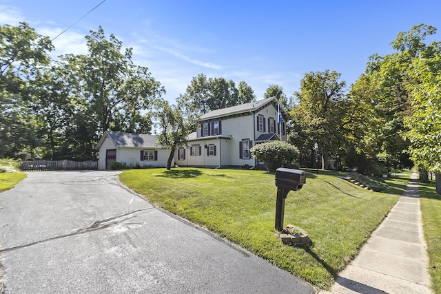 320 N Division St, Marshall, MI 49068 - view of front of house with aphalt driveway, a garage, fence, and a front lawn