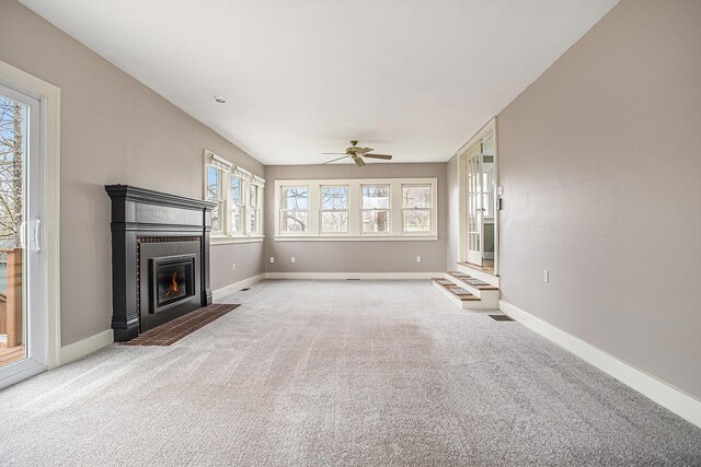 320 N Division St, Marshall, MI 49068 - unfurnished living room featuring ceiling fan, a fireplace with flush hearth, light colored carpet, visible vents, and baseboards
