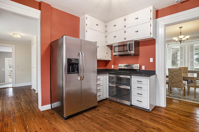 320 N Division St, Marshall, MI 49068 - kitchen featuring an inviting chandelier, dark wood-style floors, dark countertops, white cabinets, and stainless steel appliances