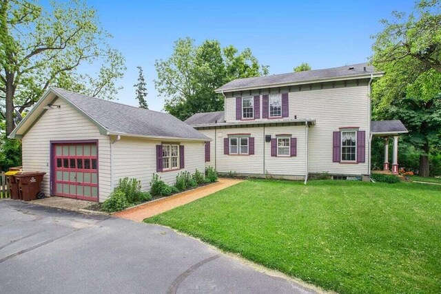 320 N Division St, Marshall, MI 49068 - view of front of home with an outdoor structure, a garage, a front yard, and aphalt driveway