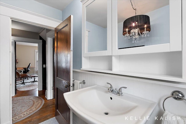 548 Pleasant St SE, Grand Rapids, MI 49503 - bathroom featuring wood finished floors, a chandelier, and wainscoting