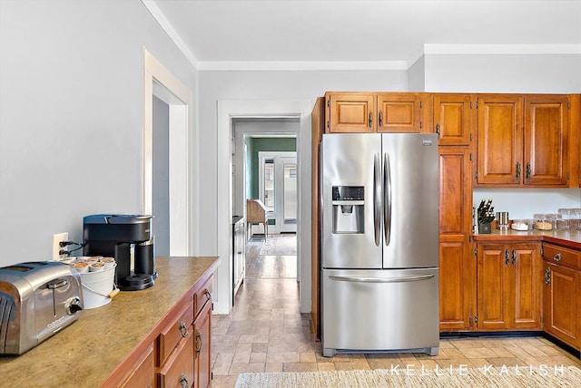 548 Pleasant St SE, Grand Rapids, MI 49503 - kitchen featuring stainless steel fridge with ice dispenser, ornamental molding, brown cabinets, and light stone finish flooring