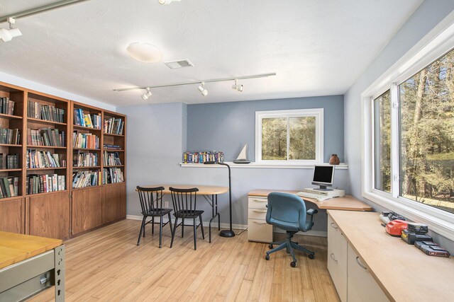 office space featuring baseboards, visible vents, track lighting, and light wood-style floors