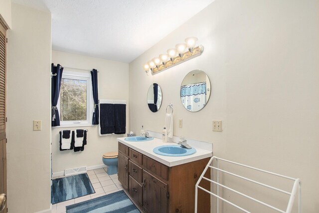 bathroom with double vanity, visible vents, tile patterned flooring, and a sink