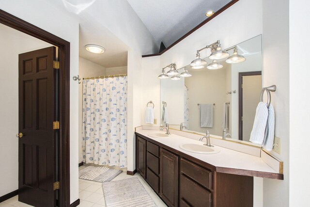 full bathroom featuring double vanity, a sink, tile patterned floors, and vaulted ceiling